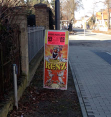 Foto von der Straße - Werbemaßen für Zirkus an der neuen Leuchte ist zu sehen.