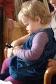 Foto von einem kleinen Mädchen mit Handy und Nuckel - heute.